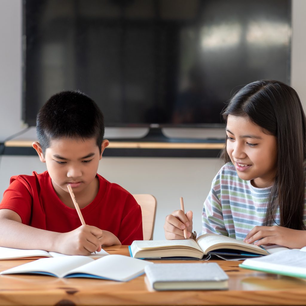 Students studying together and completing exercises with guidance from economics tuition, building strong foundations and learning confidence