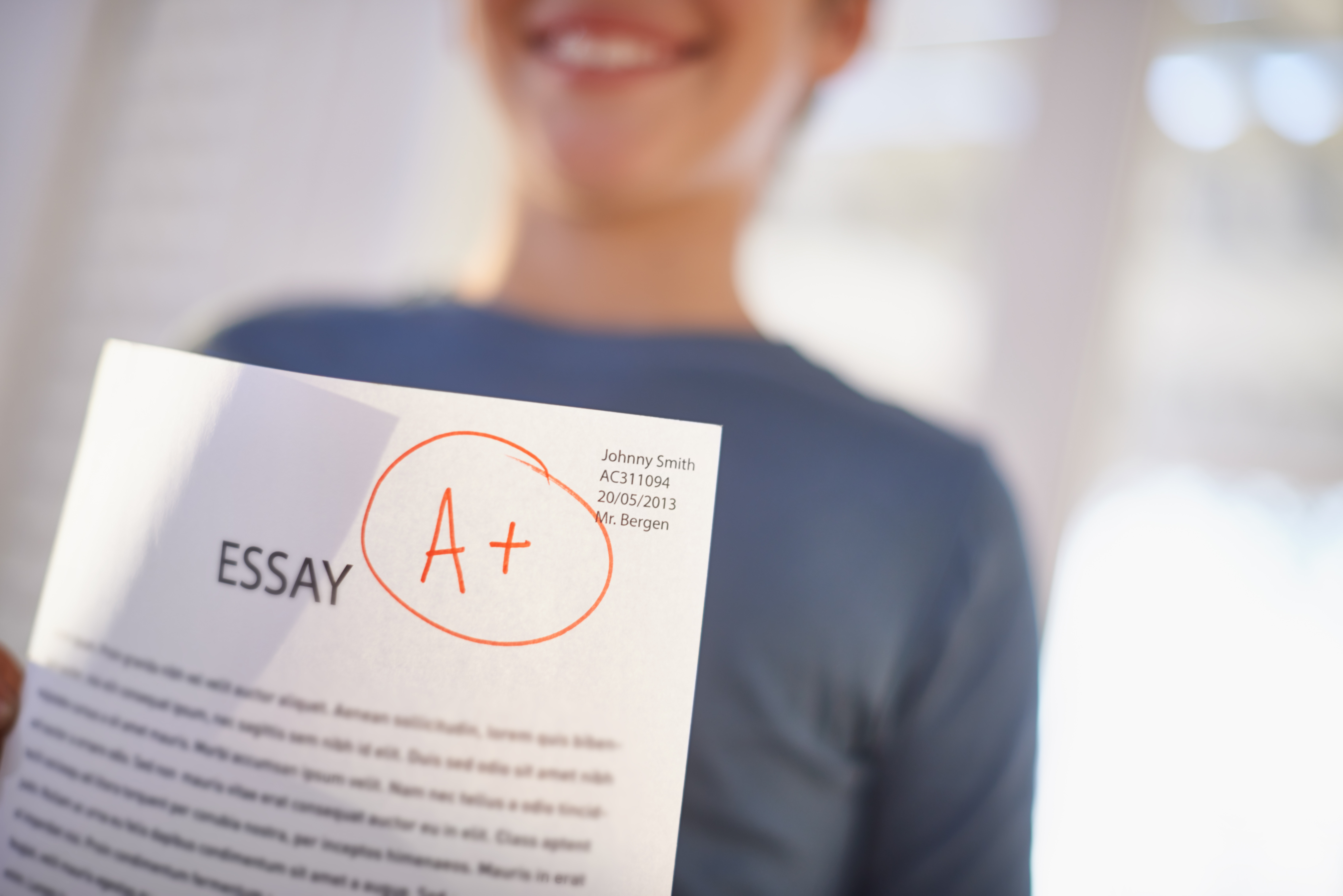 a level economics tuition student holding and essay with A+ Grade