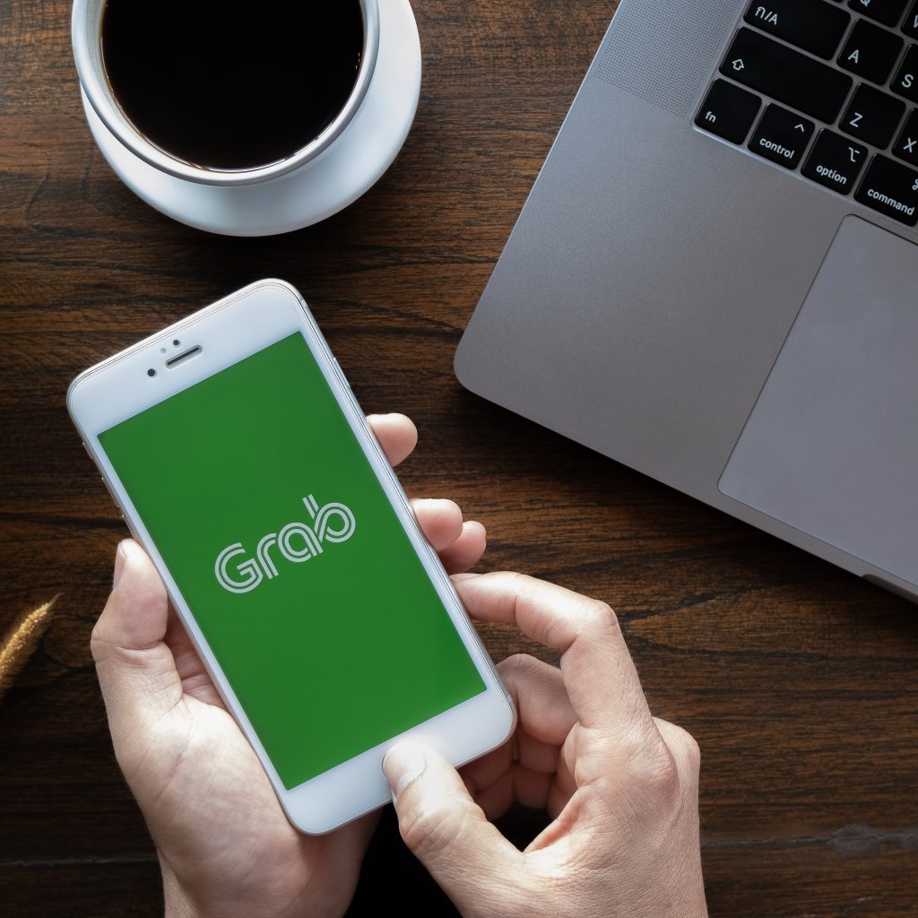 The Grab app opening on an iPhone - The Grab Uber merger is a case study usually tackled by an econ tutor for H2 Economics in Singapore