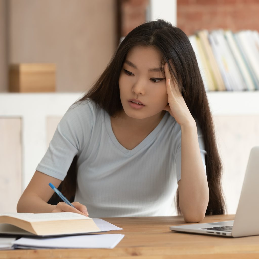 tired asian student studying for a test