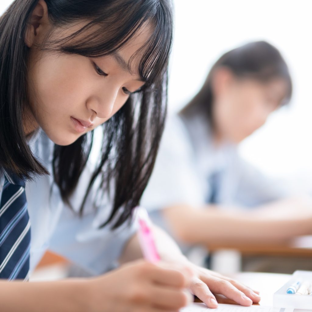 young asian student taking notes